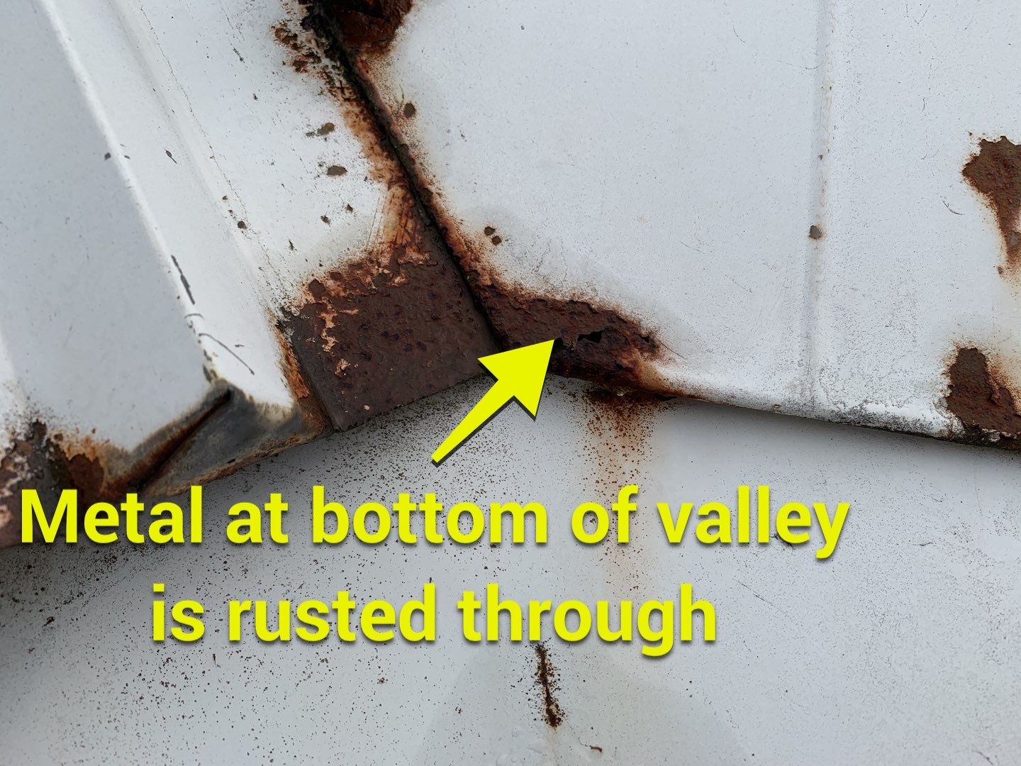 metal at bottom of valley is rusted through